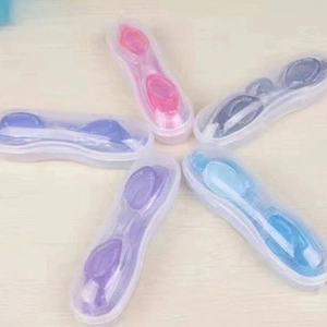 Set of five colorful swimming goggles in independent translucent storage boxes on wood