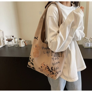Detail of canvas tote bag showing cute cartoon koala and panda prints with art text
