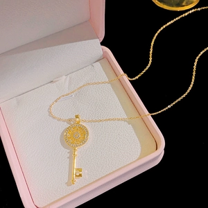 Elegant gold-tone magic key pendant necklace with cubic zirconia inlay in a pink box