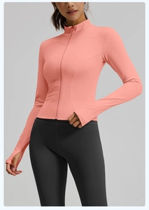 Close-up of coral pink yoga jacket with stand collar and ergonomic thumbhole cuffs