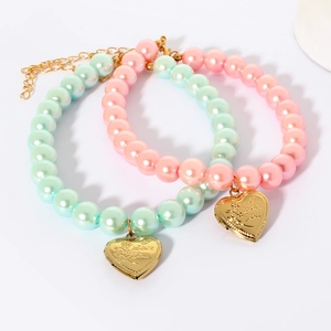 Detailed macro view of heart-shaped I Love You pendants on pink and mint bead necklaces