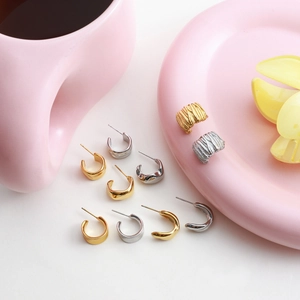 Irregular C-shaped chunky hoop earrings in 14K gold and silver stainless steel finish
