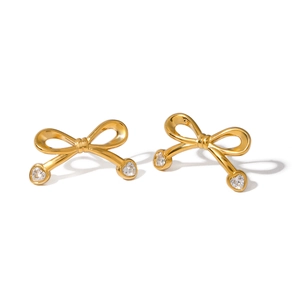 Elegant gold bow earrings with heart-shaped cubic zirconia stones on white background
