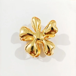 Detailed macro view of a gold five-petal flower hair claw clip with a high-polished finish