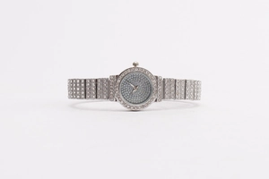 Close-up of sparkling crystals on the silver metal watch band and blue dial