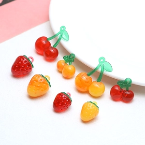 Macro shot of resin strawberry and cherry charms for DIY jewelry making
