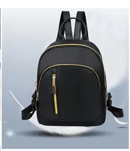 Detailed view of black nylon backpack weighing 0.26kg with golden zippers and pockets