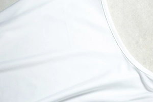 Gros plan des coutures et de la texture du tissu blanc de cet ensemble sexy deux pièces