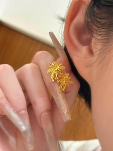 Close-up of gold-plated French floral earrings on a model showing fine texture