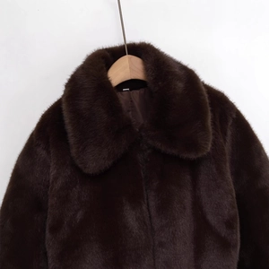 Giacca corta in pelliccia sintetica marrone con revers e texture soffice su gruccia