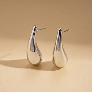 Macro detail of silver teardrop stud earrings with polished metallic surface finish