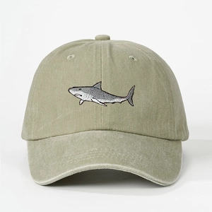 Close-up of high-quality shark embroidery on a vintage khaki washed cotton baseball cap