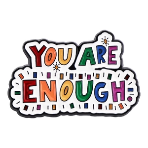 Macro shot of colorful enamel pin featuring YOU ARE ENOUGH text on white background