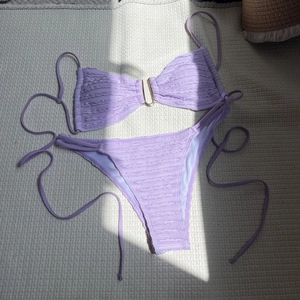 Close-up of lavender ruched bikini with U-shaped gold hardware and side-tie details