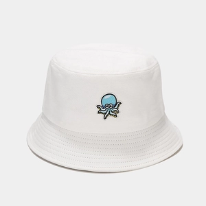 Détail de broderie de pieuvre bleue sur chapeau bob en coton blanc avec surpiqûres précises