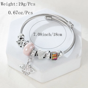 Close-up of silver beaded bracelet with heart charm and cz planet pendant detail