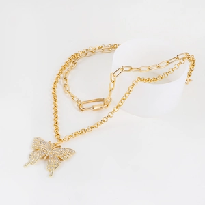 Close-up of gold double-layer necklace featuring a sparkling diamond butterfly pendant