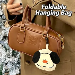 Brown Boston bag with cartoon dog charm and embossed details for winter styling