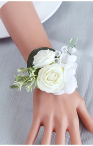 Close-up of elegant white fabric roses and lily of the valley wedding wrist corsage