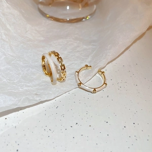 Ensemble de bagues dorées avec émail blanc et détails en strass scintillants