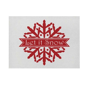 Detail of Let it Snow print on rectangular linen Christmas placemat with red snowflakes