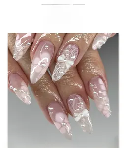 Vue détaillée de faux ongles amande courte avec motifs dentelle blanche et perles