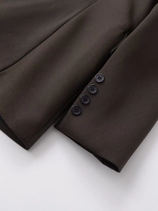 Detailed close-up of dark brown blazer sleeve cuffs with four black stacked buttons