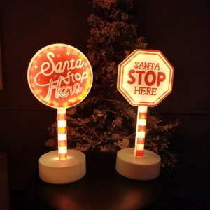 Λεπτομέρεια της πινακίδας LED Santa Stop Here με κόκκινες ρίγες και ζεστή φωτεινή βάση