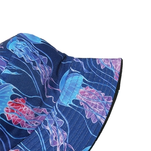 Detail of summer bucket hat featuring colorful jellyfish print on deep blue fabric