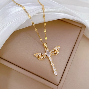 Detailed close-up of a gold-tone dragonfly pendant necklace with sparkling cubic zirconia