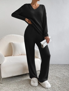 Detail of ribbed knit fabric texture on black V-neck top and wide-leg trousers set