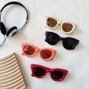 Chic thick-frame cat-eye sunglasses in various colors on a textured white surface