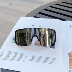 Detail of black sports sunglasses with silver mirror lens on a vintage book background