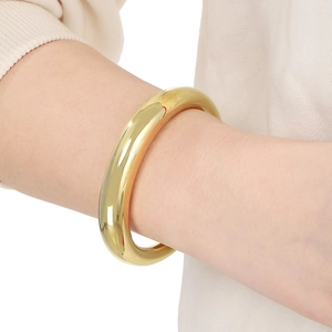Bracelet jonc minimaliste plaqué or 18 carats au poignet avec finition polie et éclat
