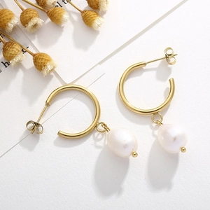 Détail de créoles en or 18K avec surface polie et pendentifs en perles blanches