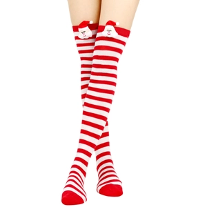Detail of red and white striped over-knee socks with 3D plush Santa Claus decoration
