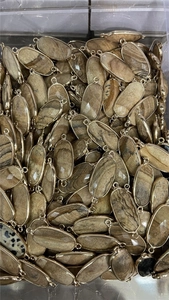 Macro shot of oval natural stone pendants with gold-plated double-loop connectors