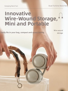 Portable gray folding neck fan being placed into a stylish handbag for outdoor storage