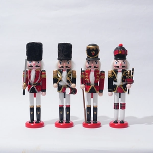 Set of four wooden Christmas nutcracker soldiers in red and gold outfits on white background