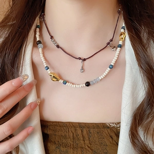 Close-up of vintage acrylic coffee bean beads layered necklace on female model neck