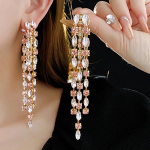 Elegant gold-tone tassel earrings featuring pink rhinestones on a black background