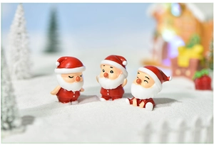 Detailed view of three mini resin Santa Claus figurines in a snowy winter micro landscape
