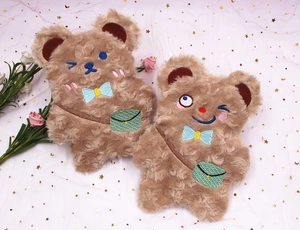 Détail de trousses à crayons en peluche ours brun avec broderies et nœuds papillon