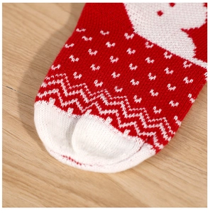 Macro shot of knitted Christmas stocking toe with red and white festive wave patterns