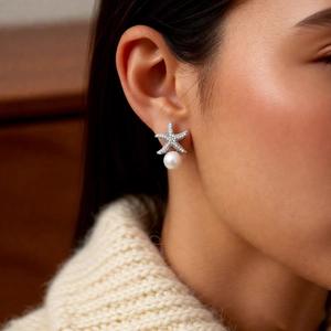 Close-up of starfish pearl earring with zircon pave setting worn by a model