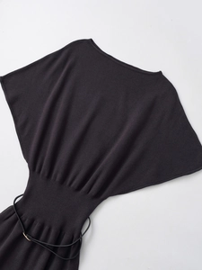 Flat lay of a black knit dress with batwing sleeves and matching rope belt details