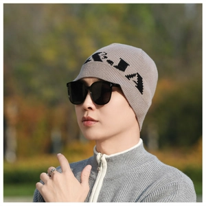 Detail of a thick knitted beanie with letter embroidery and soft warm texture
