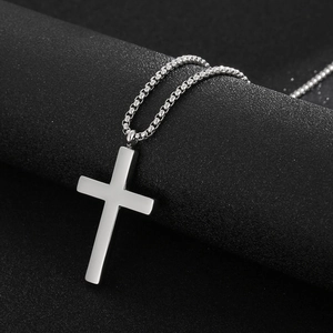 Minimalist silver stainless steel cross pendant necklace with box chain on dark background