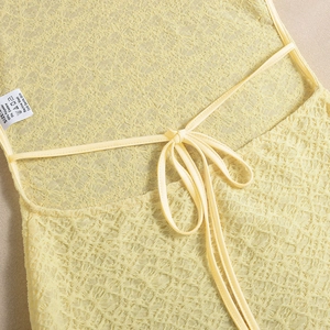 Détail du dos d'une robe jaune avec texture dentelle et élégant nœud papillon à lacets