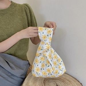 Floral cotton wristlet bag featuring yellow flower patterns on a white fabric base